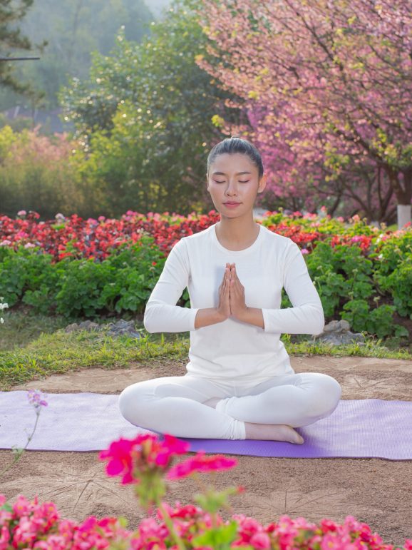 Women are playing yoga at the park. Exercising.